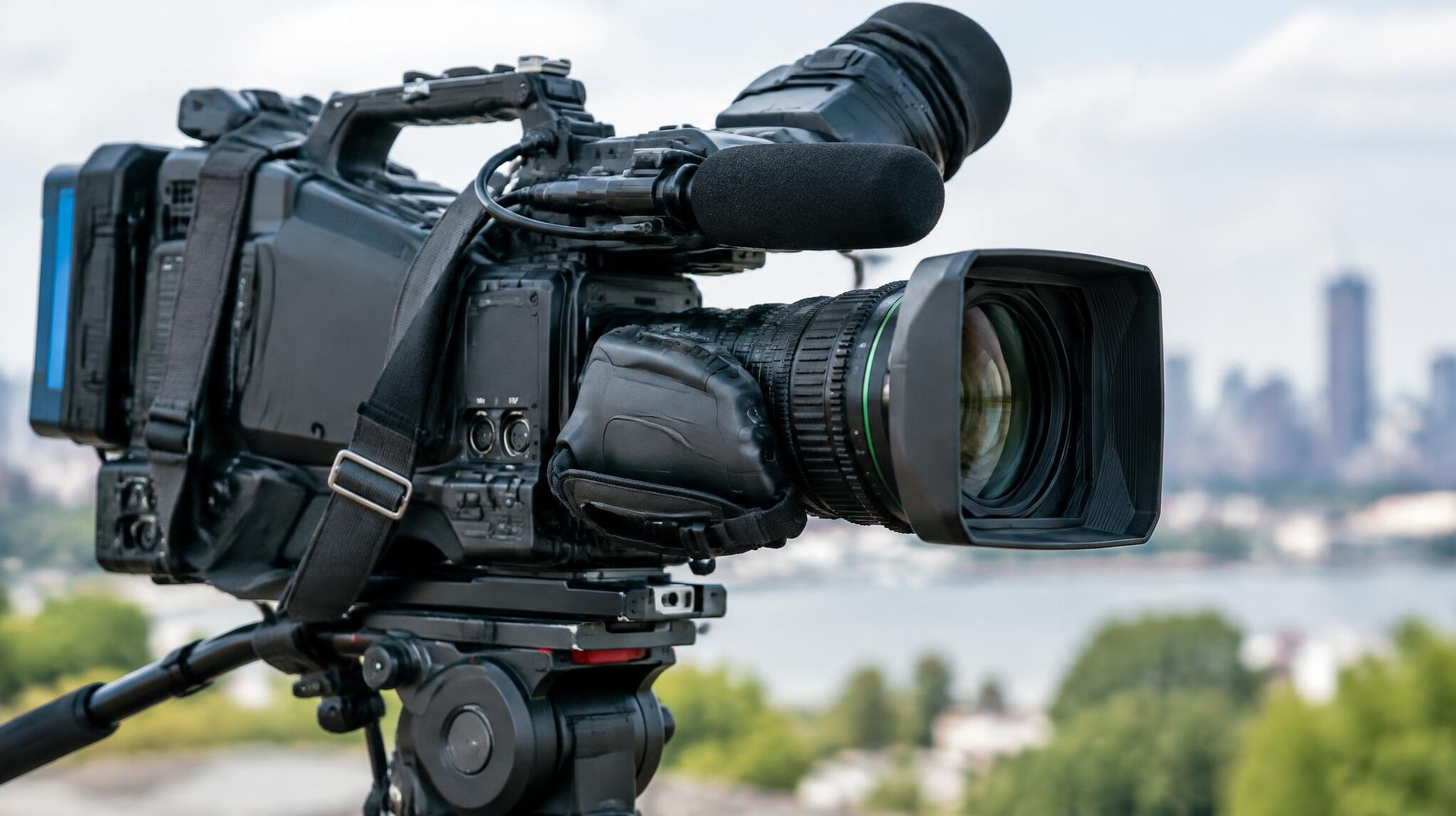 Close-up of a shoulder-mounted broadcast news camera lens and viewfinder